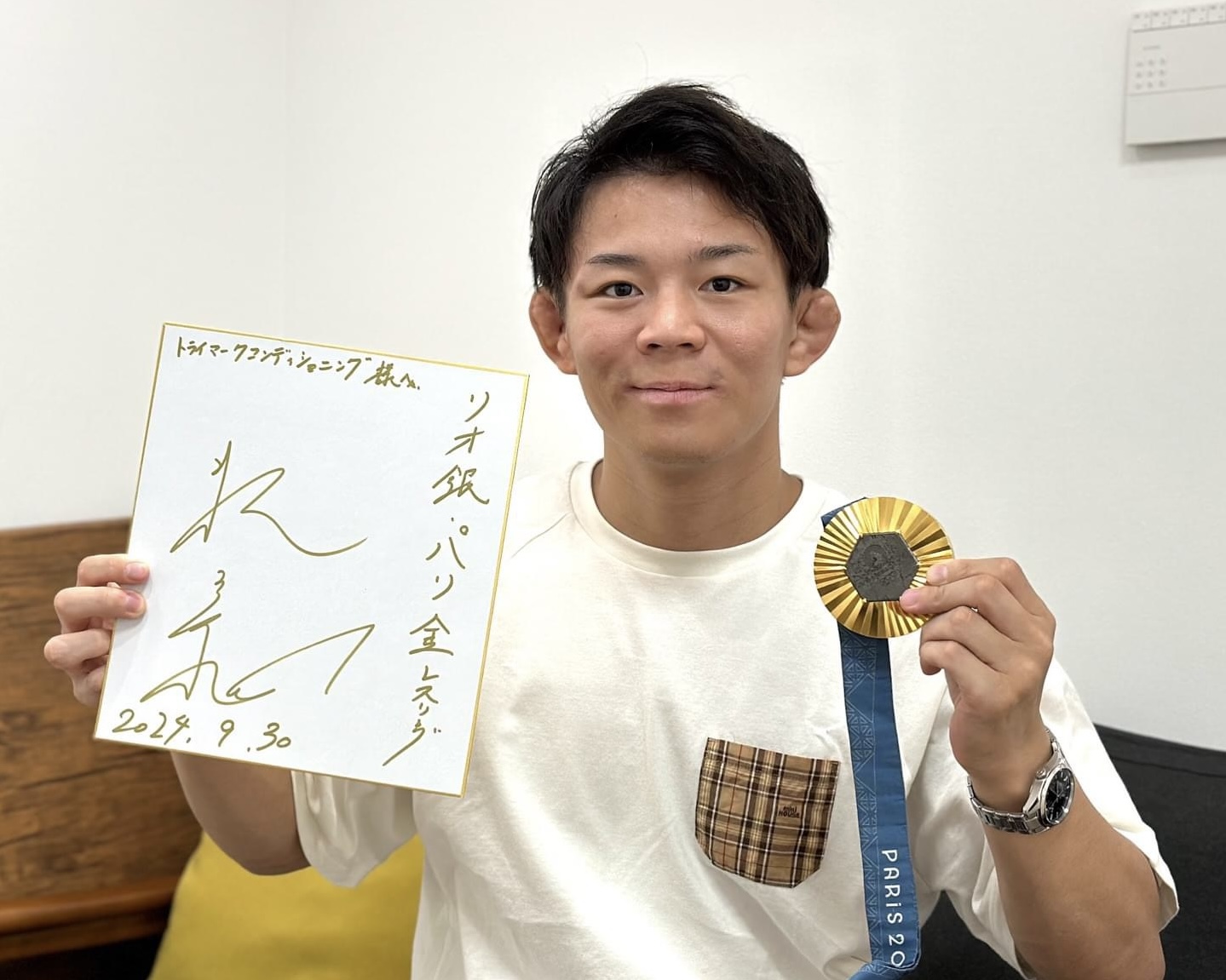 スポーツトレーナー活動 金メダルとサイン入りディスプレイを持つ樋口黎選手の来店記録