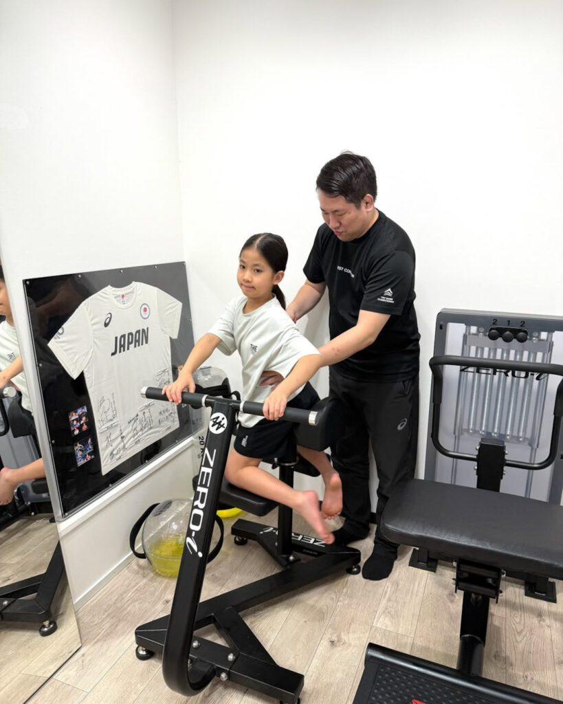 小4・空手選手の保田結衣選手に、ZERO-iストレッチマシンを使った指導を行っている様子