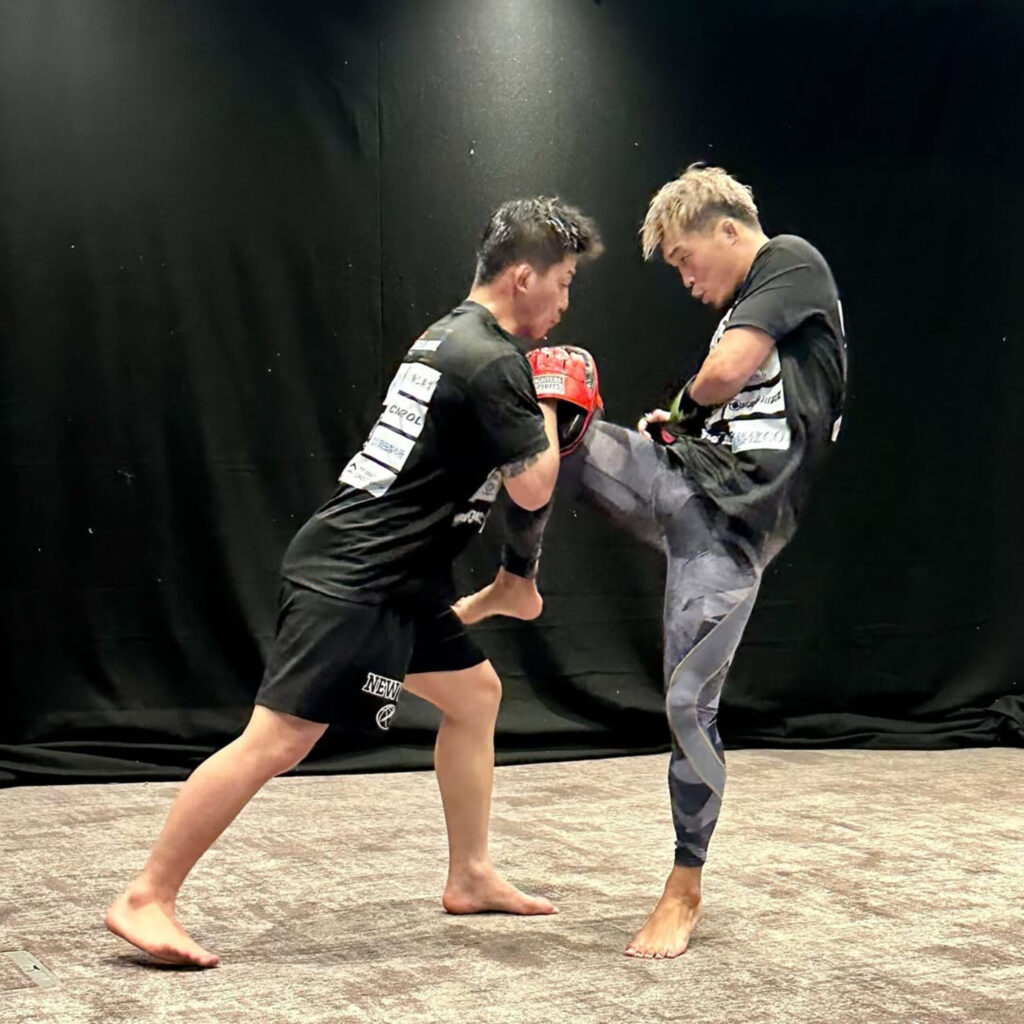 太田忍選手がミットに強烈な左膝を打ち込む場面。動作確認と感覚調整の最中